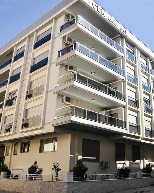 Emine Hanım Apartmanı: geniş balkonlu, açık renk cepheli köşe apartmanı