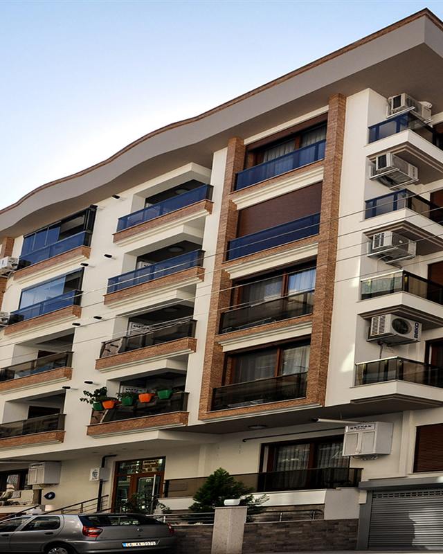 Hacıoğlu Apartmanı: kahverengi dikey hatlı, uzun cepheli apartman